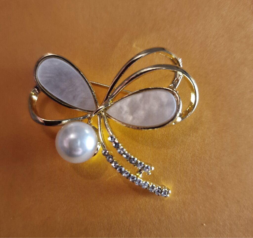 bow style brooch on an orange background