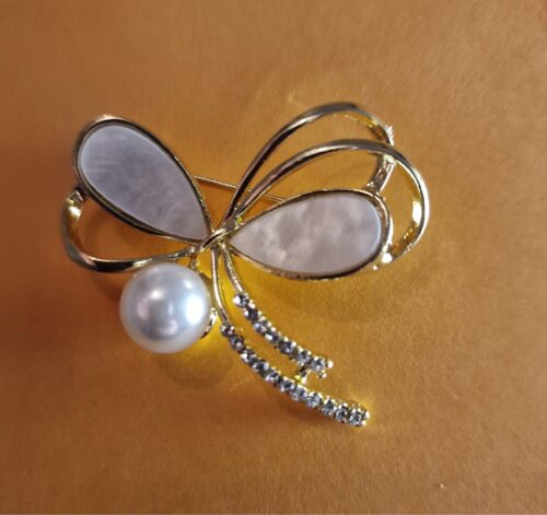 bow style brooch on an orange background
