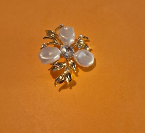 three petal pearl brooch on orange background