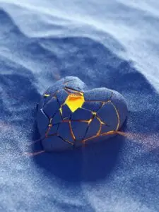 broken heart on sand with a light glowing