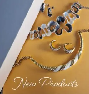 A collection of gold and silver jewellery on gold coloured card