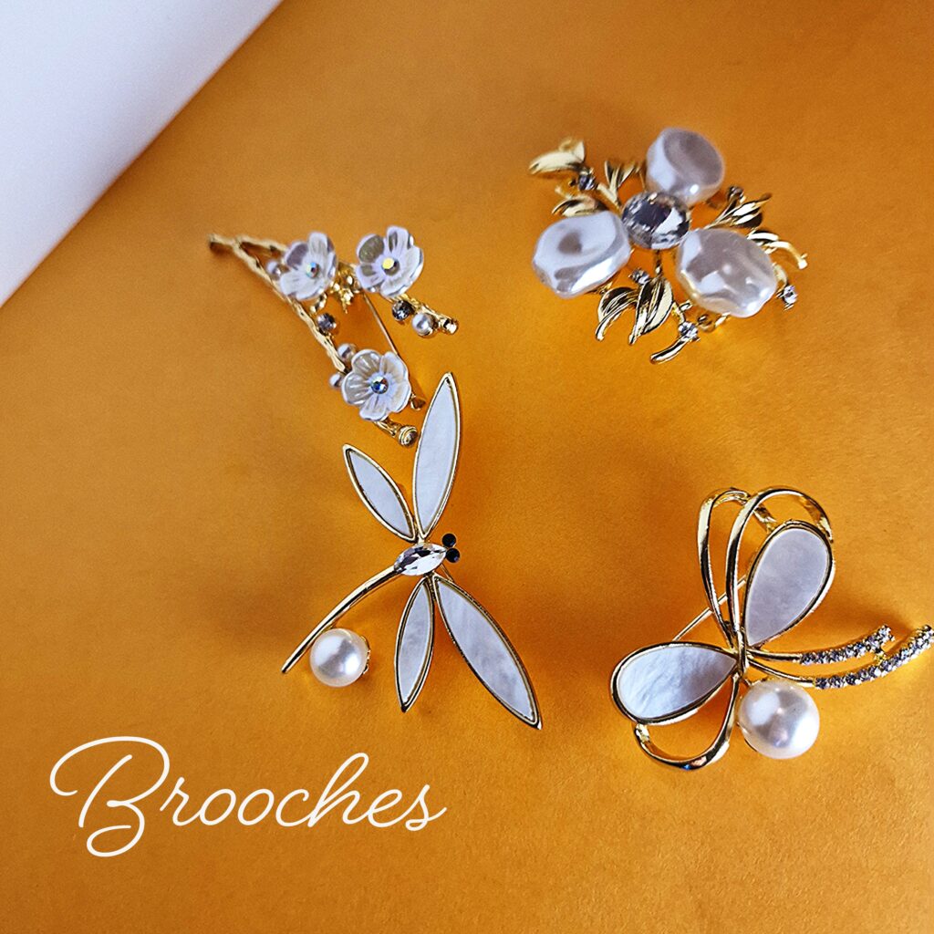 A collection of brooches on an orange background