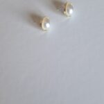gold plated earrings with pearl on a white background