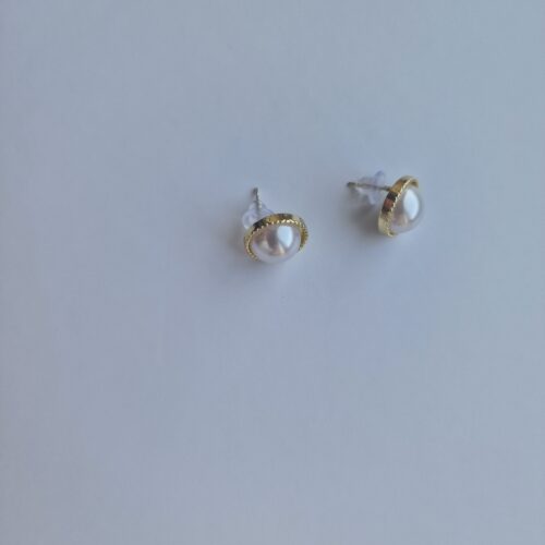 gold plated earrings with pearl on a white background
