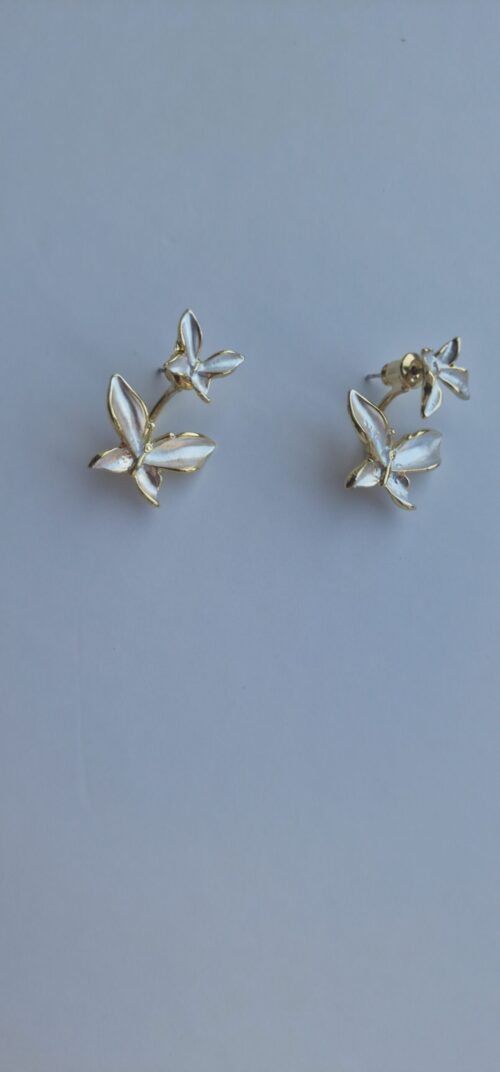 Double butterfly gold earrings with pearl detail on a white background.