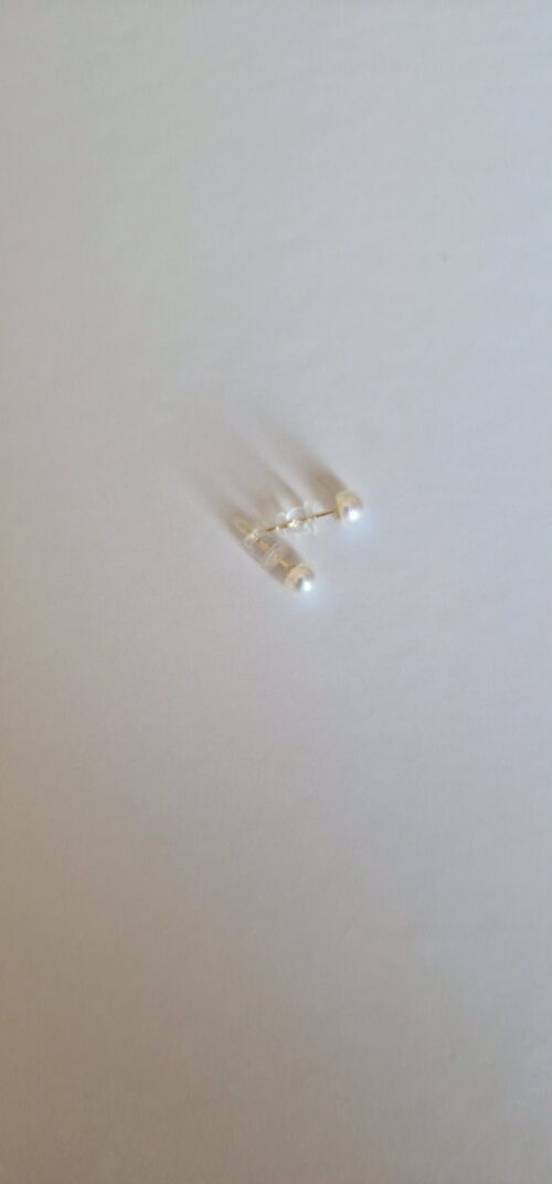 Two stud pearl silver earrings on a white background