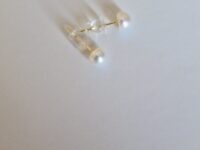 Two stud pearl silver earrings on a white background
