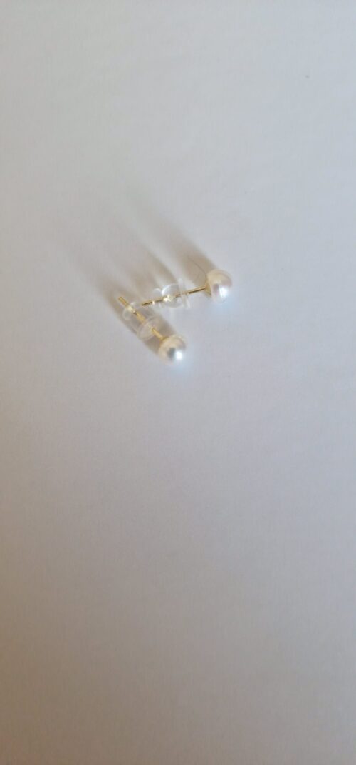 Two stud pearl silver earrings on a white background