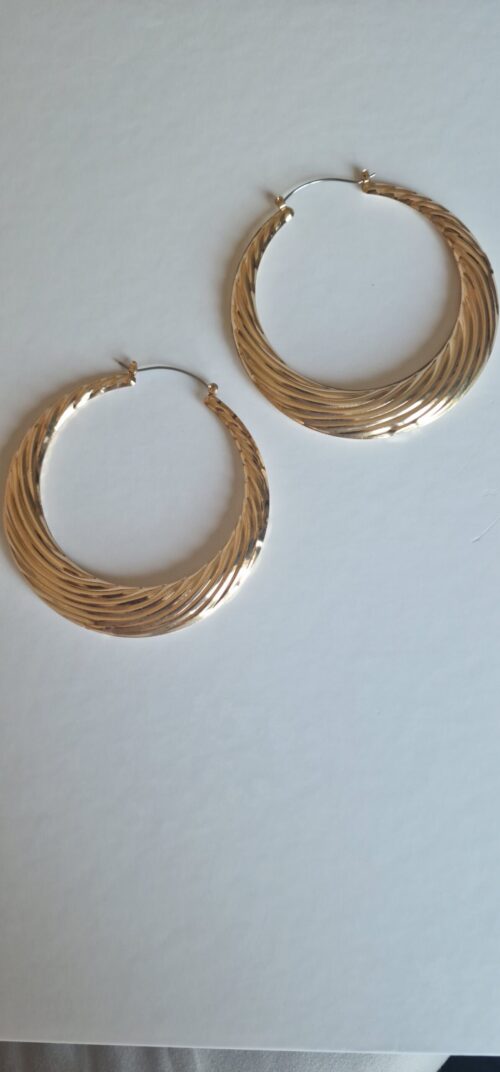 Big statement gold hoop earrings on a white background.