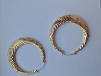 Big statement gold hoop earrings on a white background.