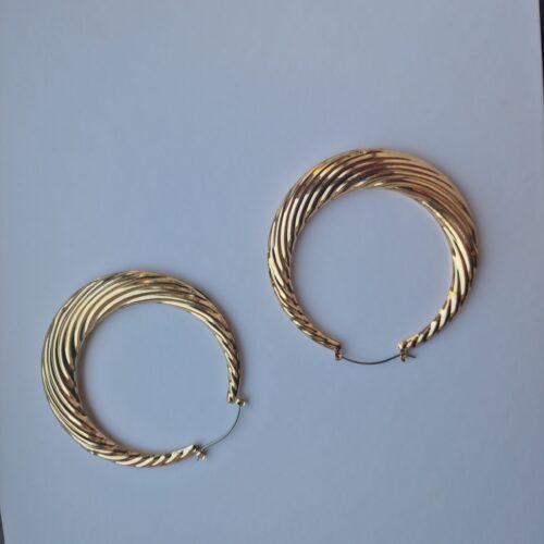 Big statement gold hoop earrings on a white background.