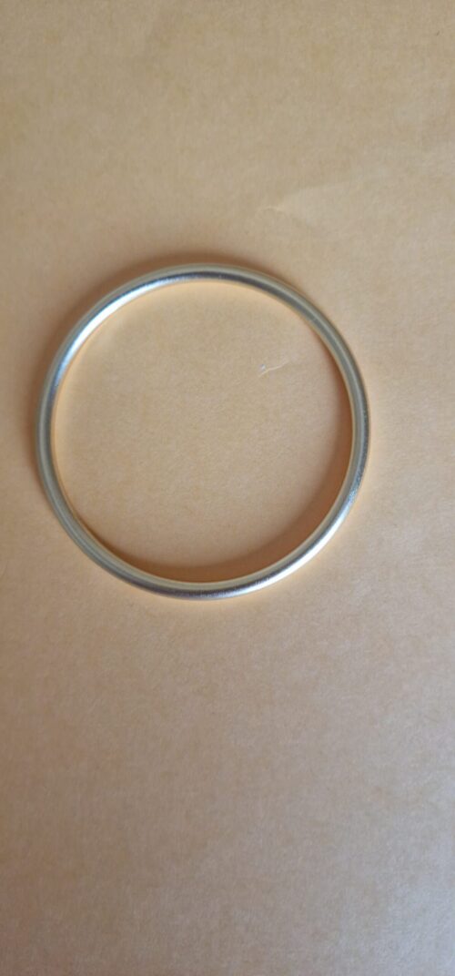 Bold gold bracelet on a orange background.