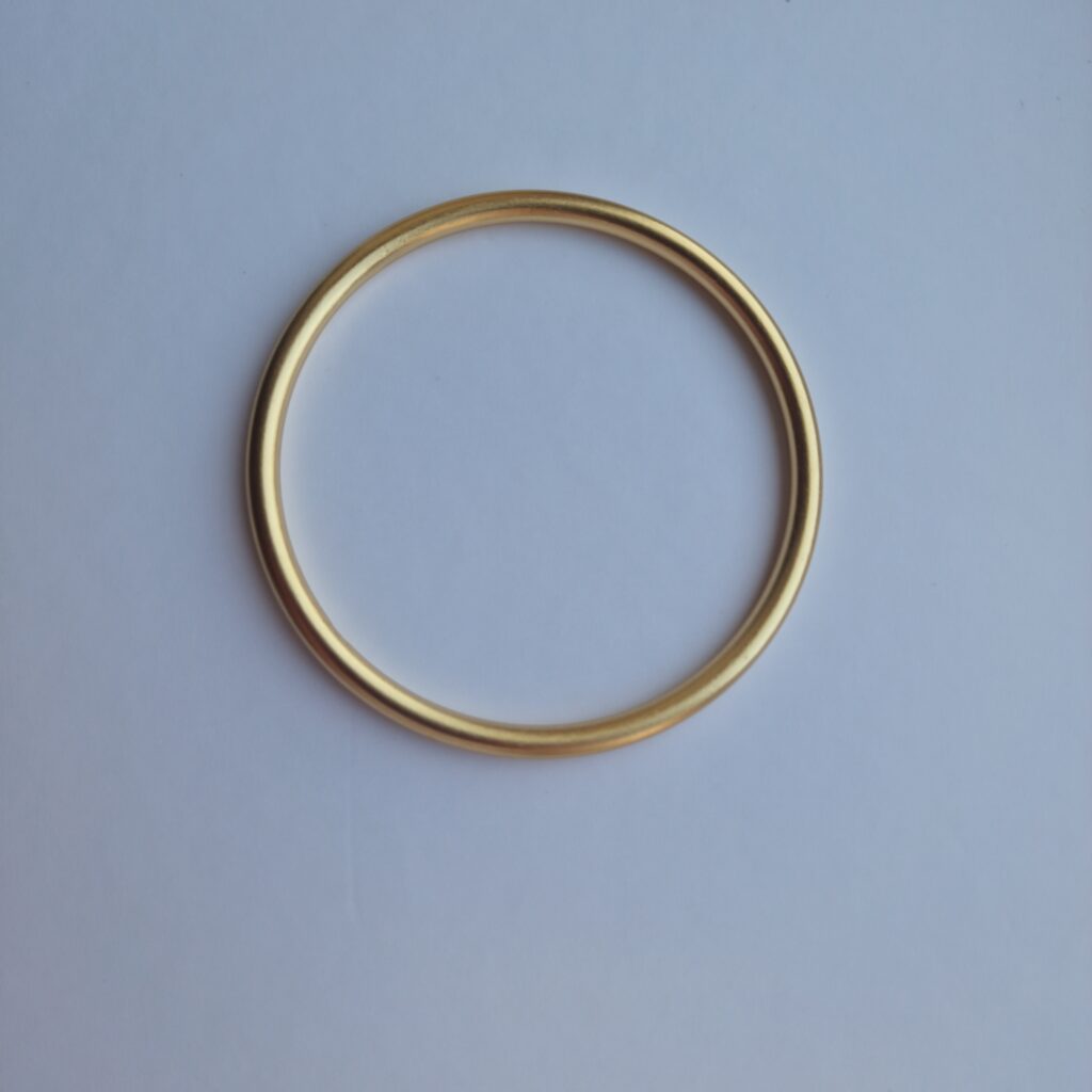 Bold gold bracelet on a white background.