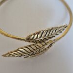 The bracelet is a small size. Gold leaf bracelet on a white background.