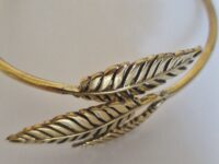 The bracelet is a small size. Gold leaf bracelet on a white background.