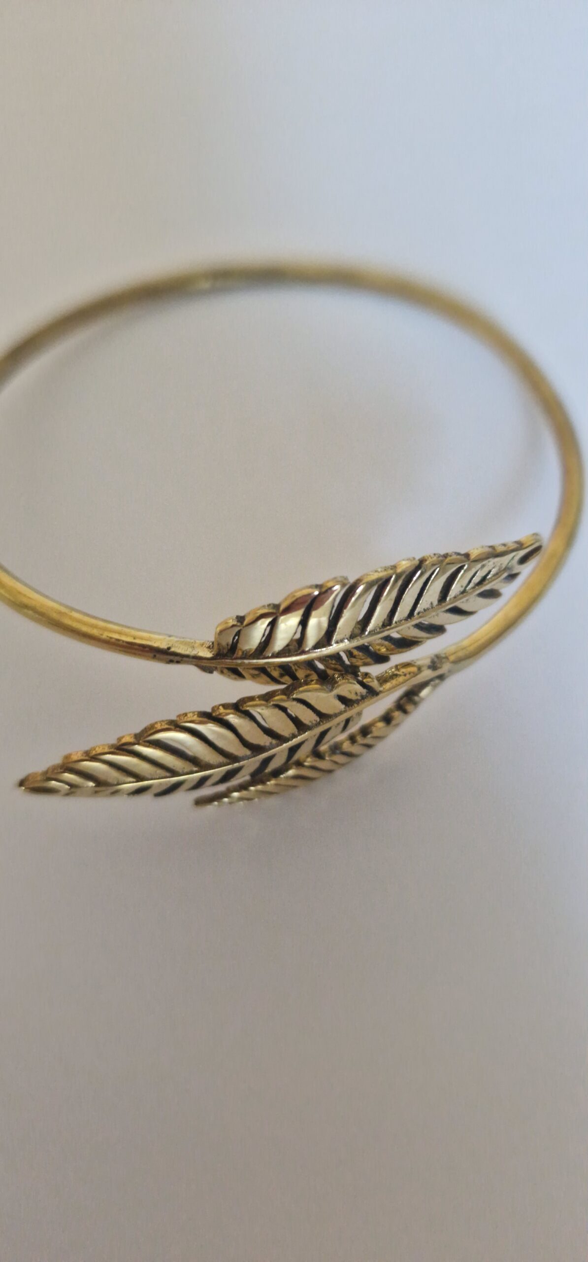 The bracelet is a small size. Gold leaf bracelet on a white background.