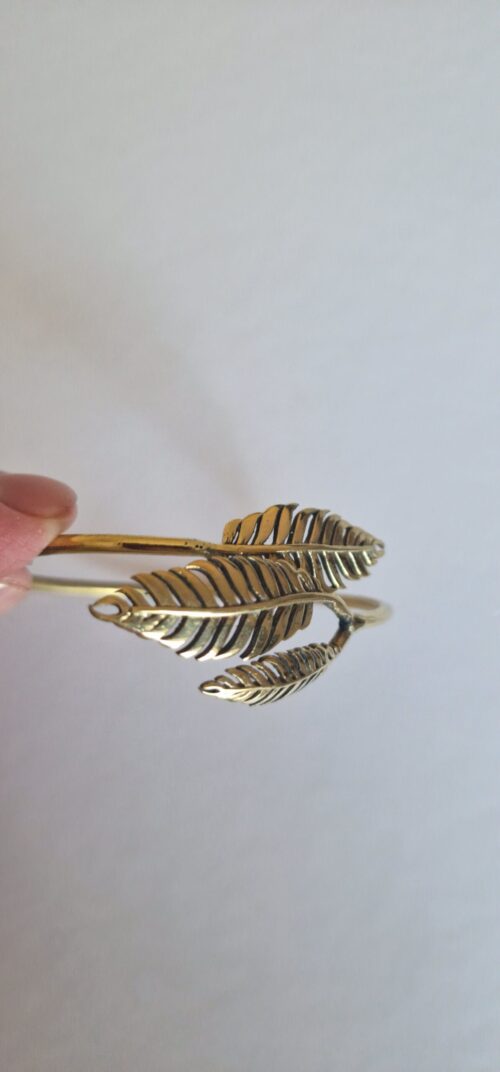 The bracelet is a small size. Gold leaf bracelet on a white background.