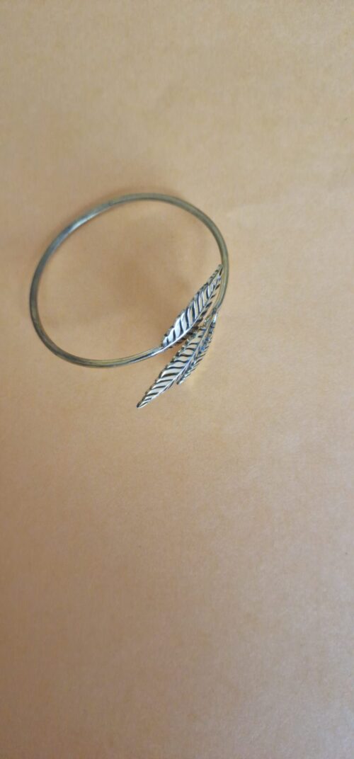 The bracelet is a small size. Gold leaf bracelet on a orange background.