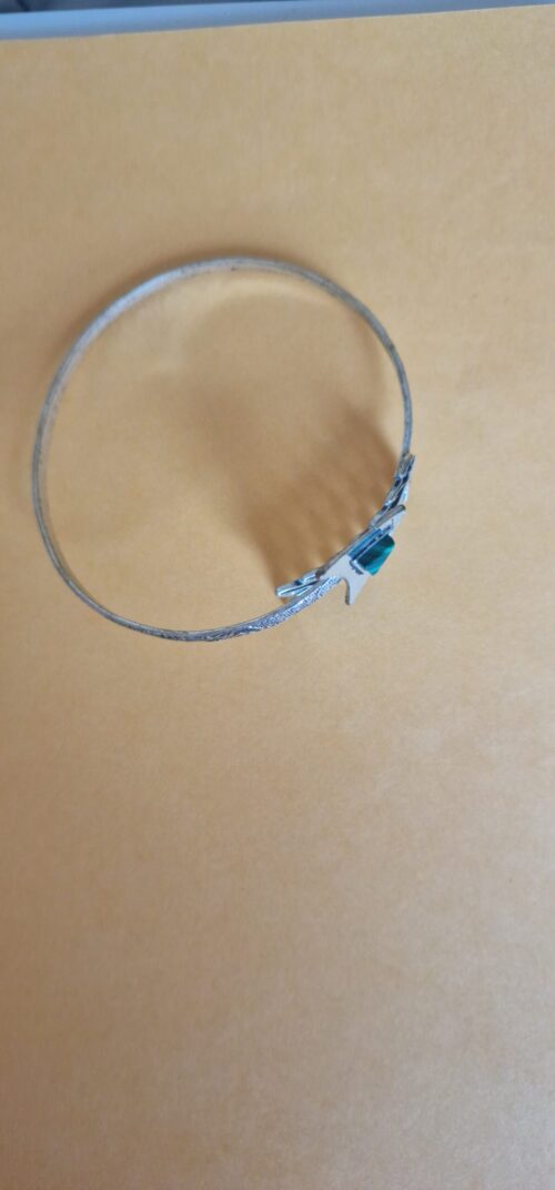 Silver Feather and Arrow Armband (Don Bell) on a orange background.